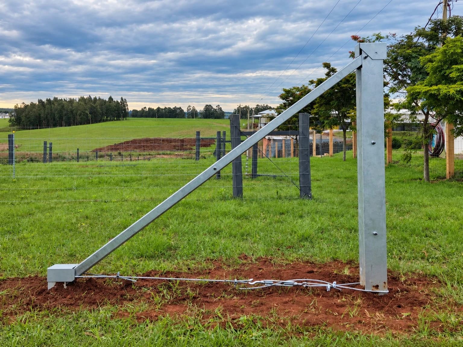 Sistema Pau Ferro com poste metálico, escora diagonal e conexões em cerca rural